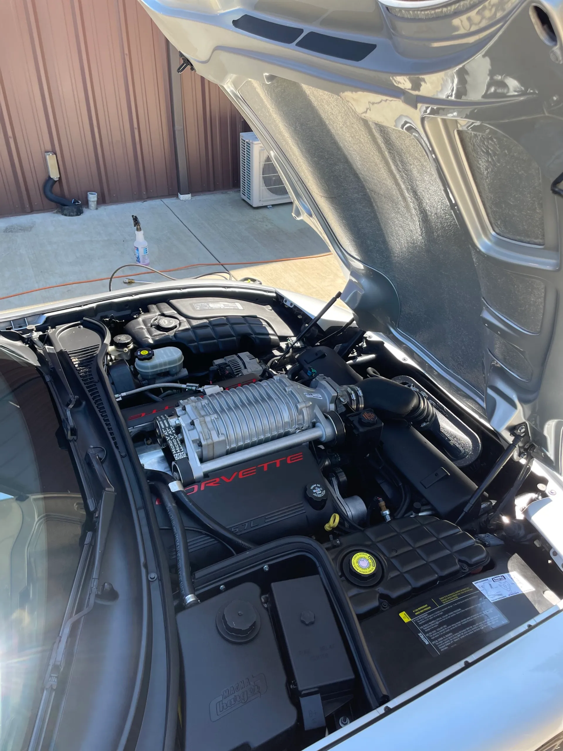Supercharged Corvette engine bay with the hood raised, cleaned and dressed