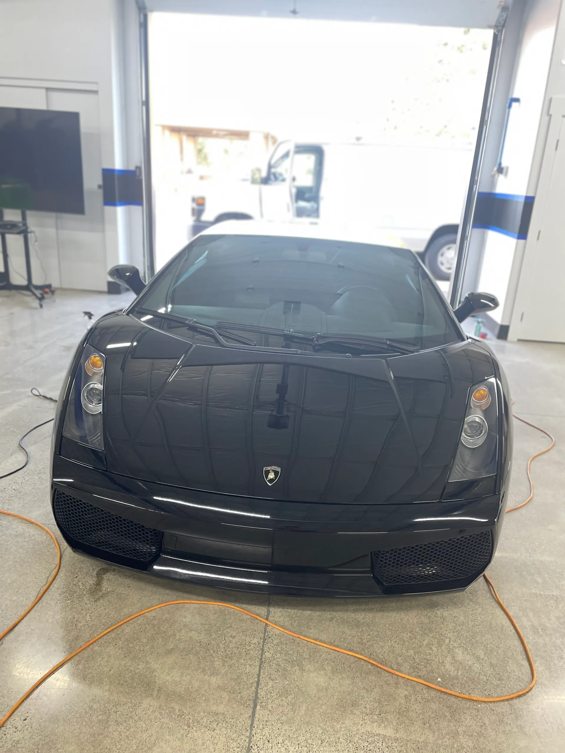 Black Lamborghini Gallardo facing the camera in the detailing bay