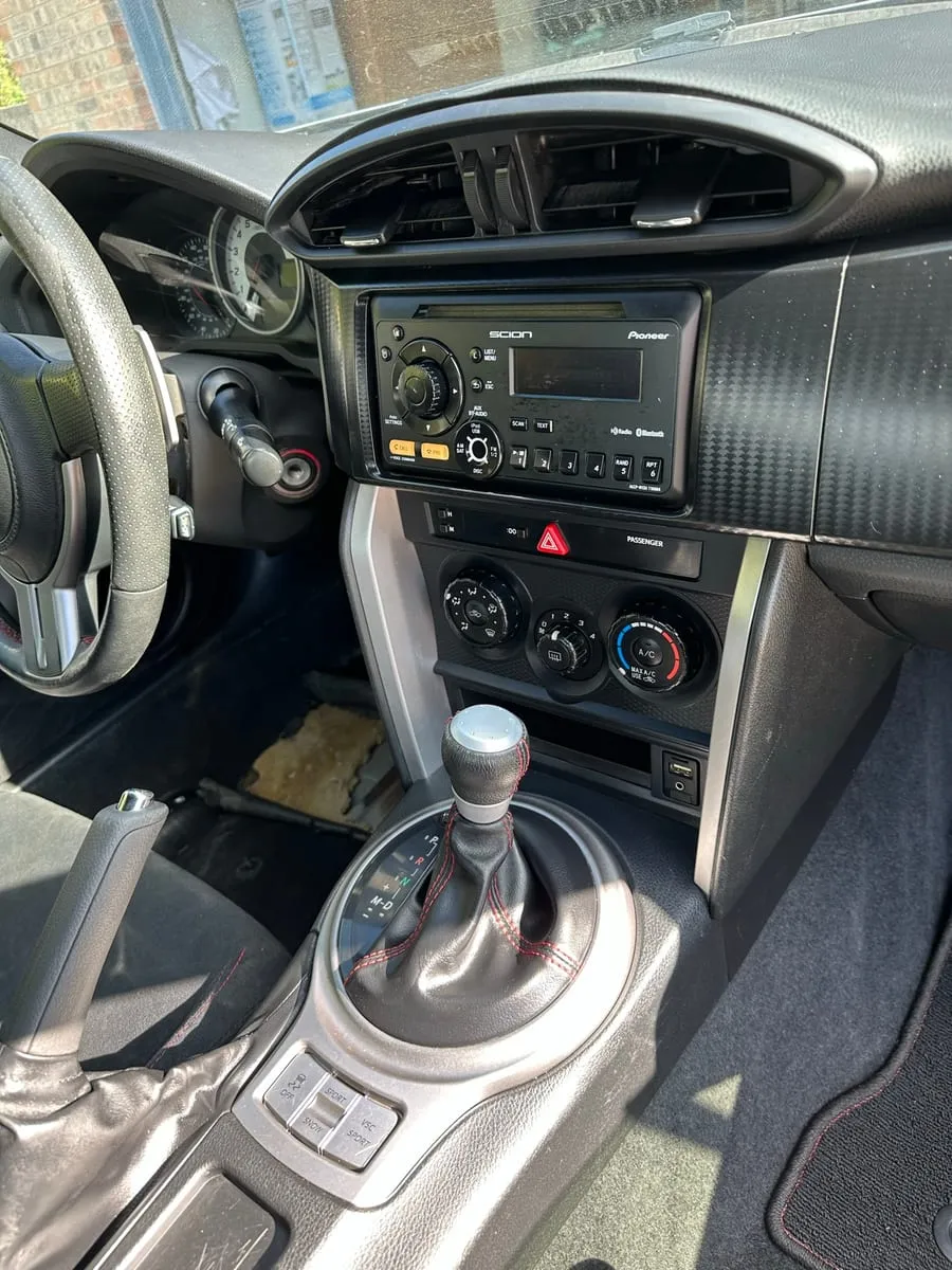 The same Scion FR-S console cleaned, the silver shifter surround and radio buttons clear of dust